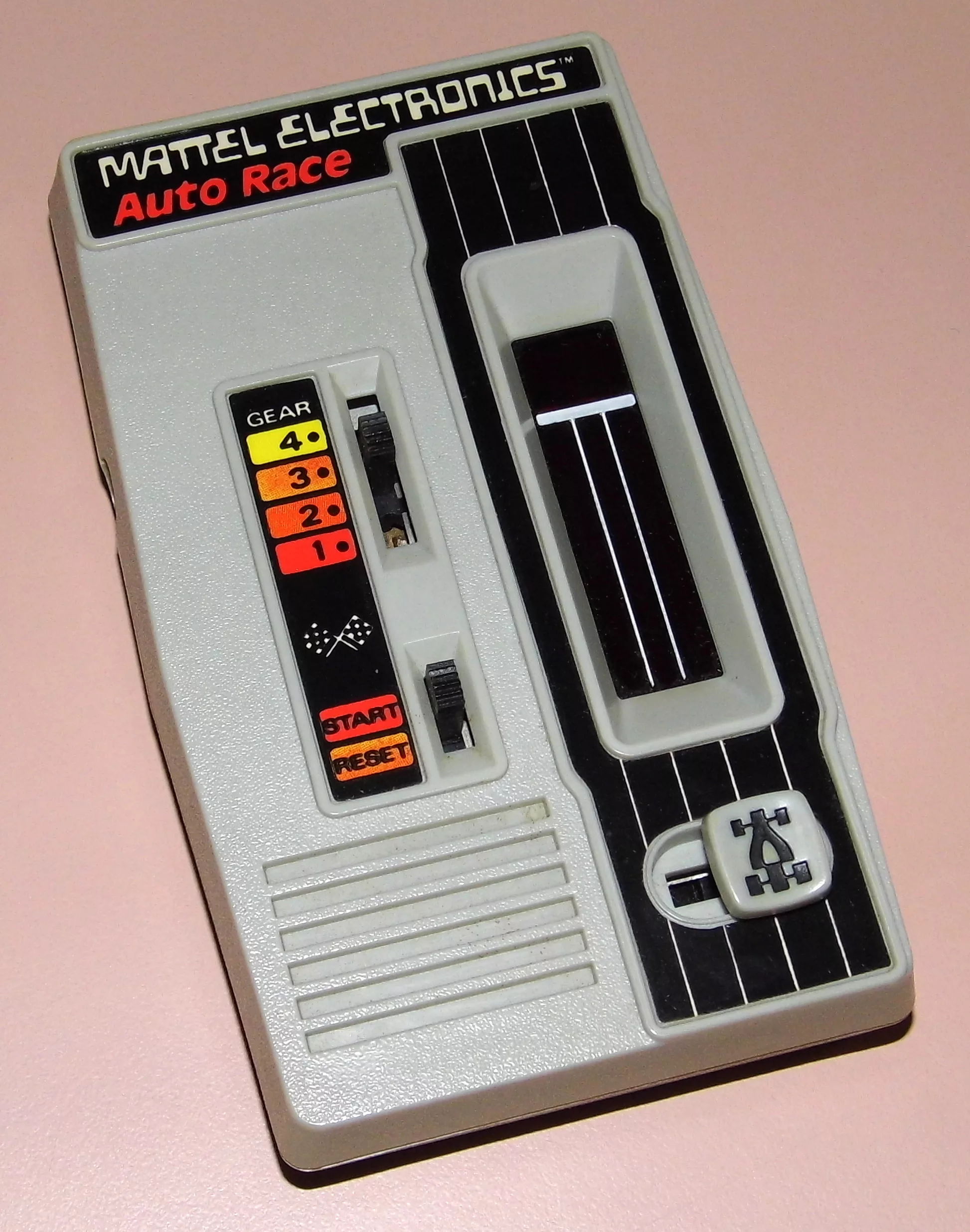 Mattel Electronics Auto Race handheld game from 1976, showing the gear switch, start/reset slider and red LED racetrack window