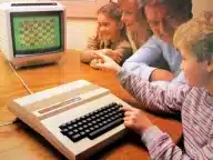 A family gathered around a Dragon 32 playing a chess program, from a period advertisement.