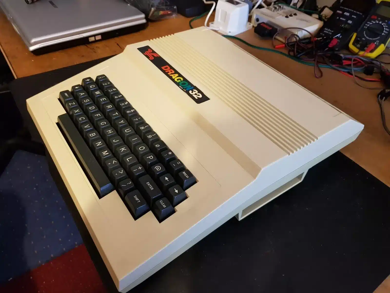 A Dragon 32 home computer with its distinctive cream case and Dragon 32 badge, sitting on a workbench