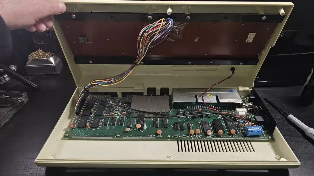 Lifting the top half: the keyboard cable is still connected to the board