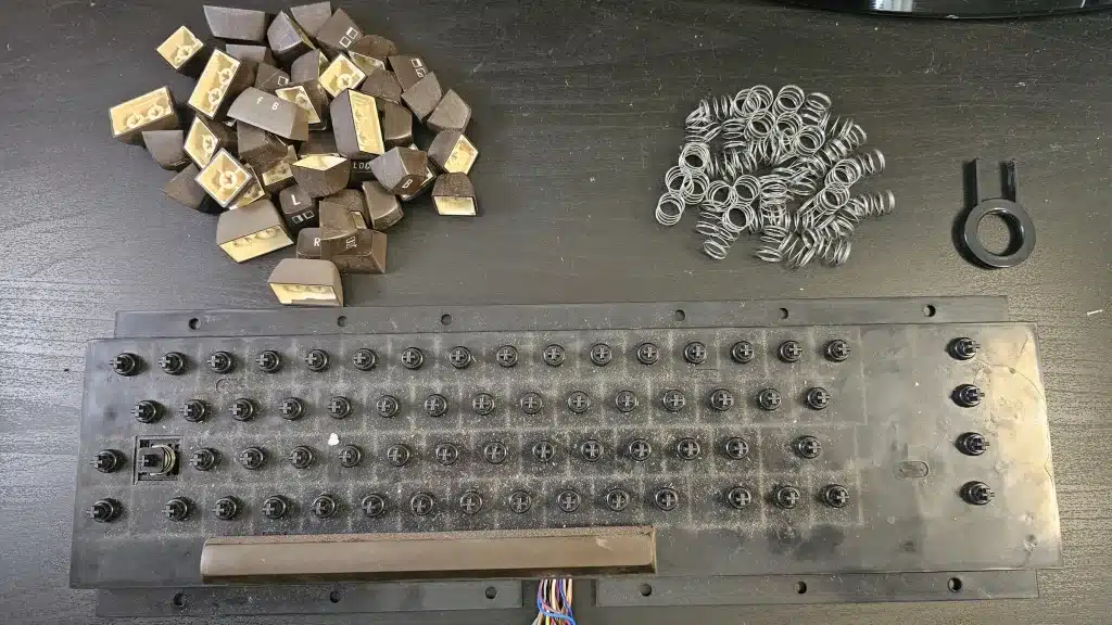 The keyboard with its keycaps and springs off