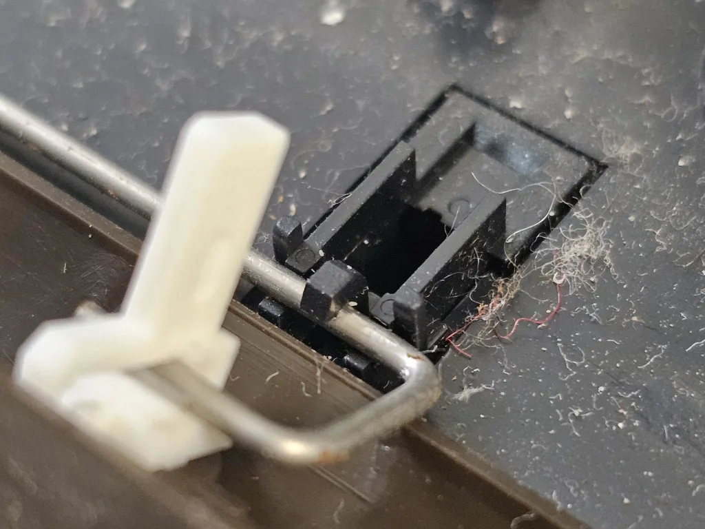 The space bar's metal rod and its holder, with the keycap lifted