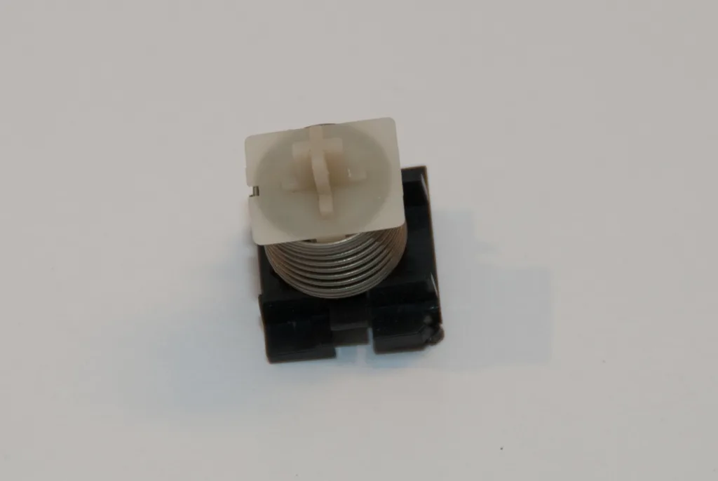 A single Osborne 1 key switch with its coil spring