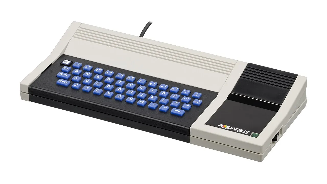 Mattel Aquarius home computer with blue rubber keys and a beige case on a white background