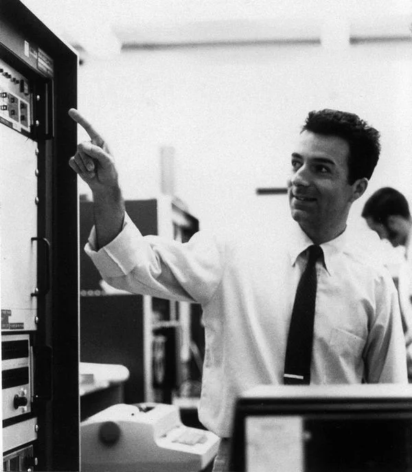 Federico Faggin pointing at equipment in a laboratory