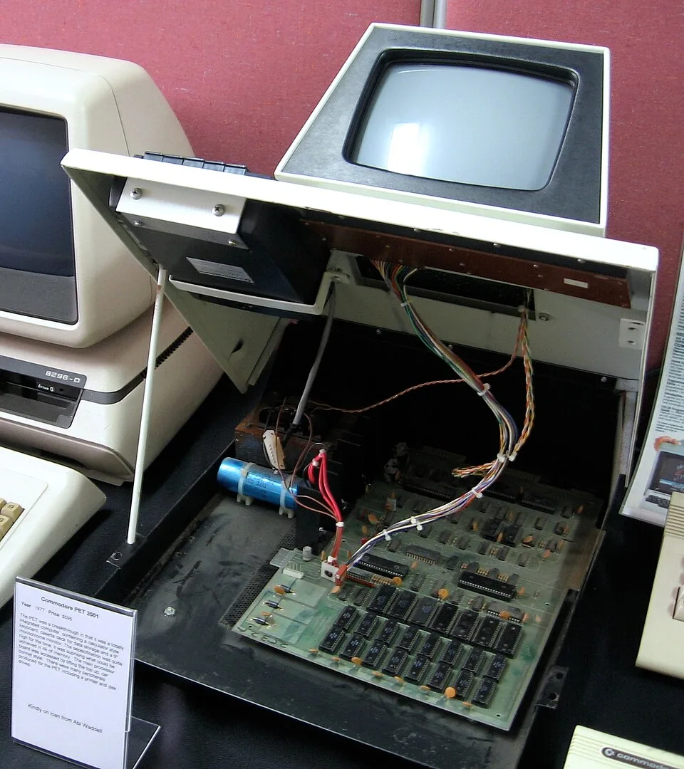 Inside a Commodore PET 2001 with the lid raised, showing the logic board and a large reservoir capacitor